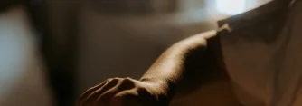 Close-up of a person's arm and hand in soft lighting