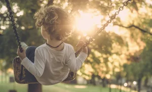 A child enjoying a sunny day on a swing.
