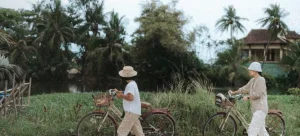 Two cyclists enjoying a ride in a scenic field by a river.