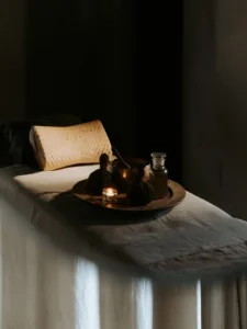 A massage table set up with candles and a towel for a relaxing spa experience.
